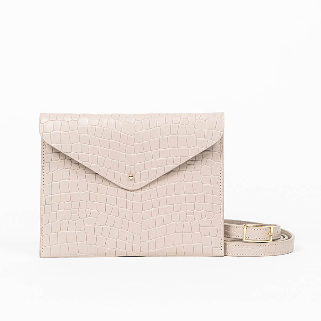 Beige leather clutch bag with a strap on a white background