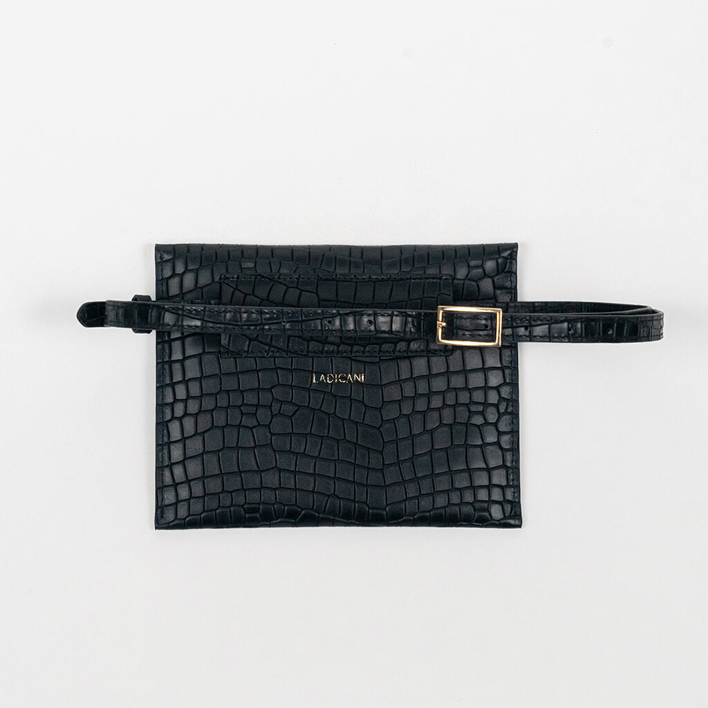 Back of a black leather clutch bag with a strap on a white background