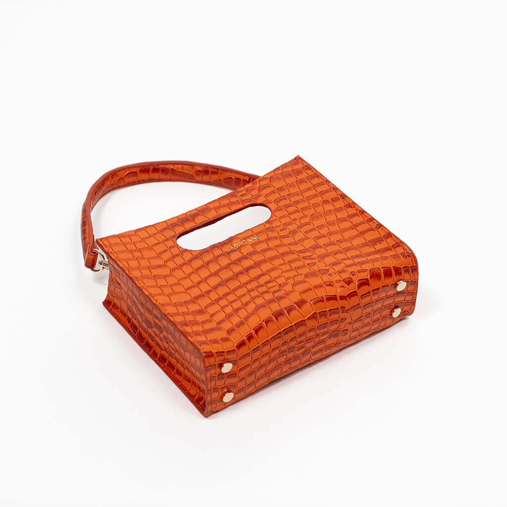 Orange textured cassette bag with a visible brand logo and strap on a white background