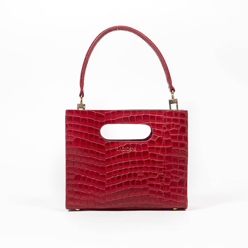 Red textured cassette bag with a visible brand logo and strap on a white background