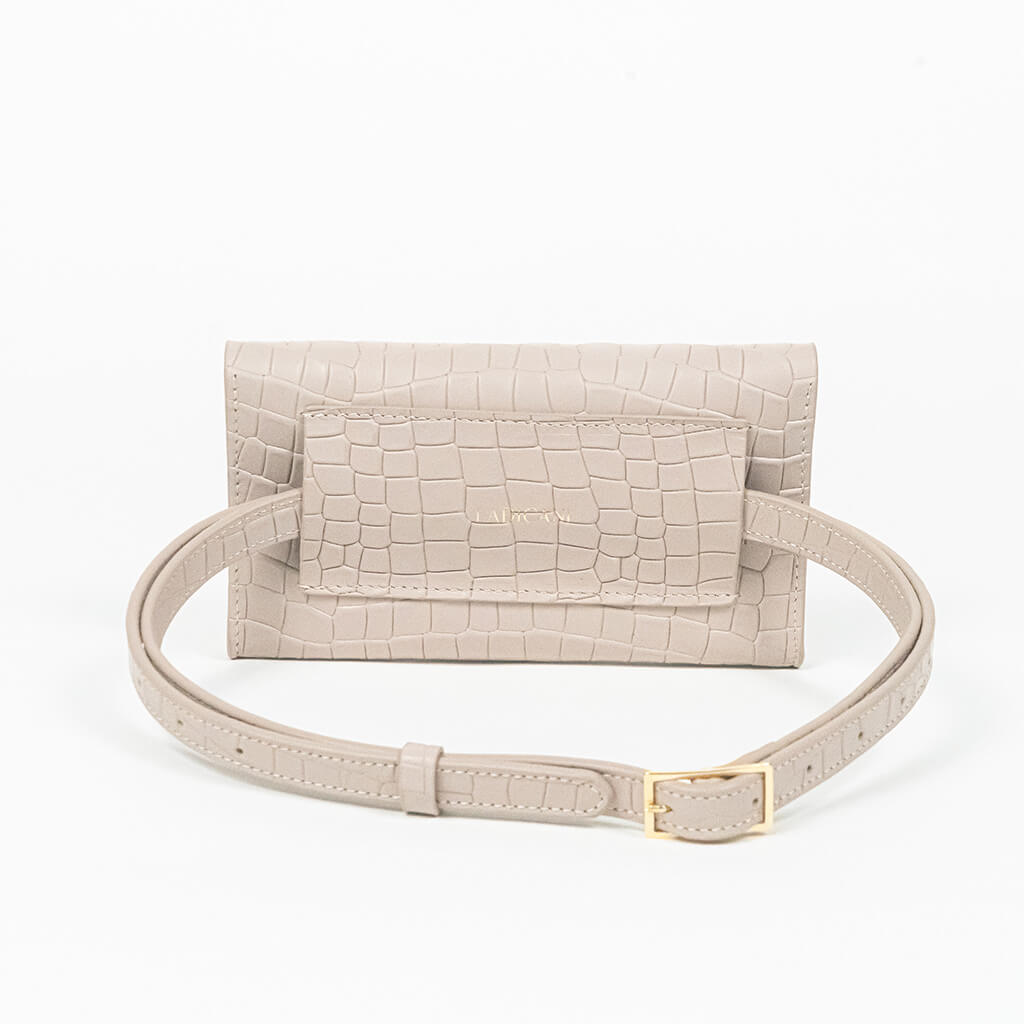 Back of a beige mini clutch bag with matching belt on a white background