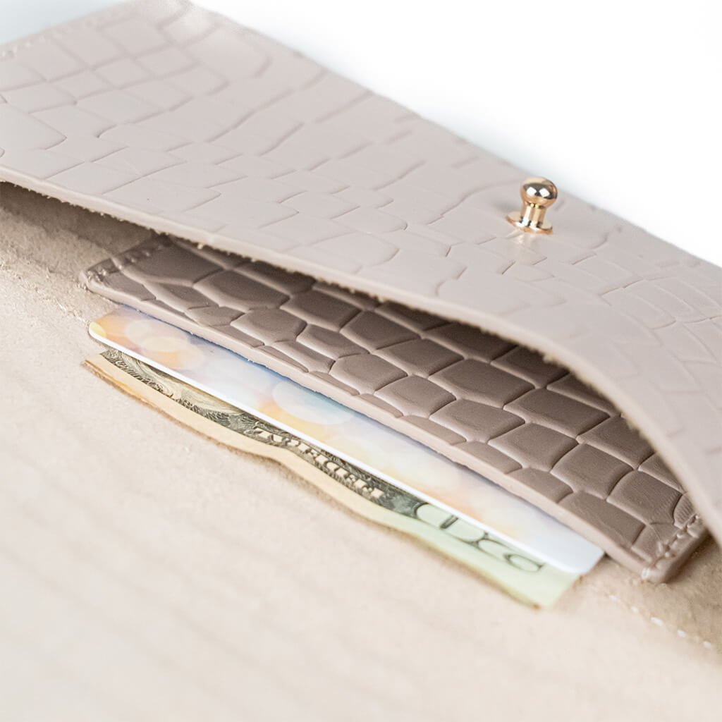 Closeup of a beige mini clutch bag on a white background