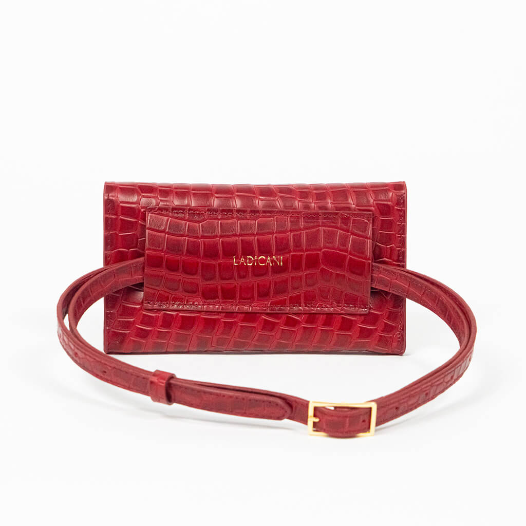 Back of a red mini clutch bag with matching belt on a white background