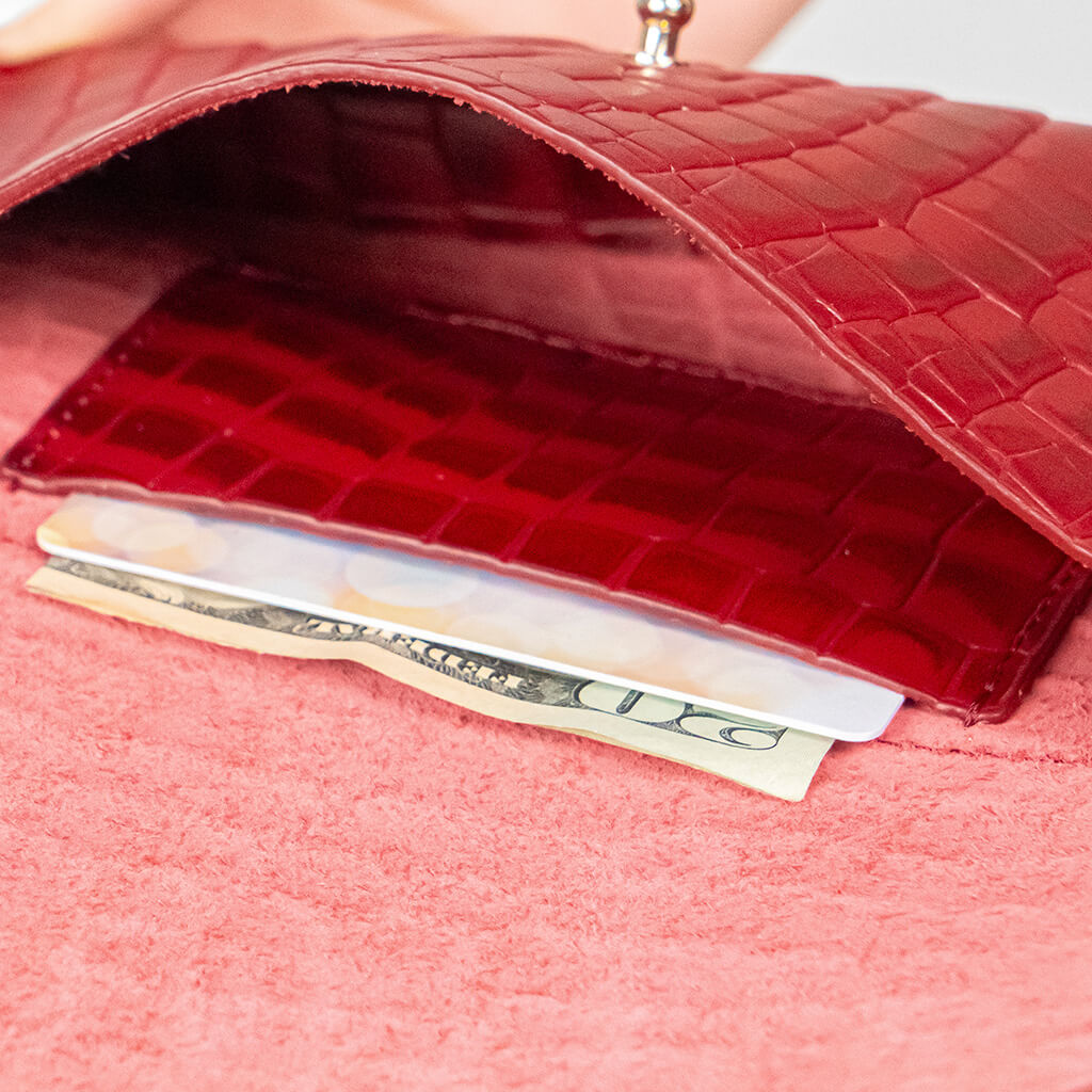 Closeup of a red mini clutch bag on a white background