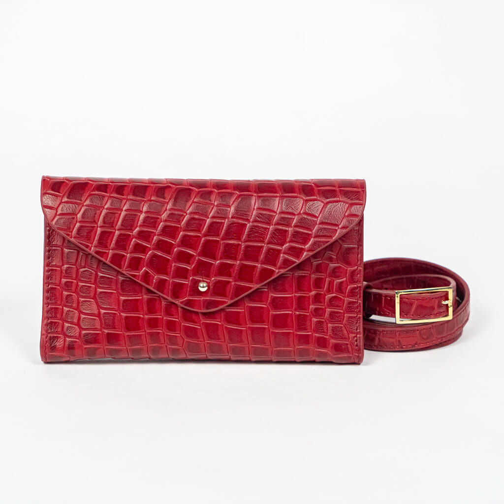 Red mini clutch bag with matching belt on a white background