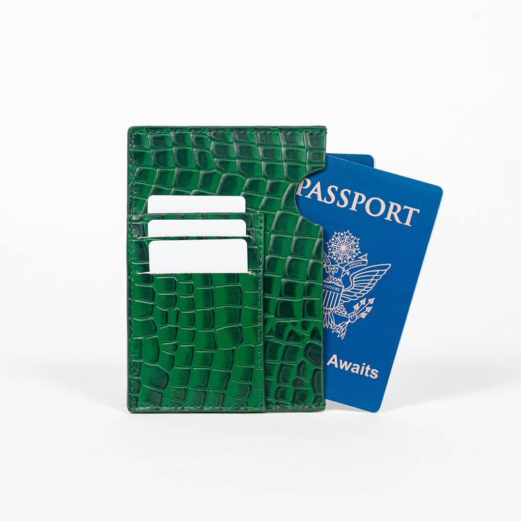 Green leather passport holder with a blue passport on a white background