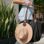 Black leather hat holder attached to a brown leather handbag