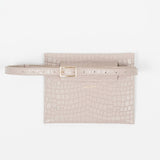 Back of a beige leather clutch bag with a strap on a white background