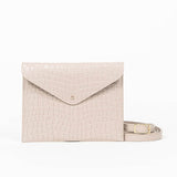 Beige leather clutch bag with a strap on a white background