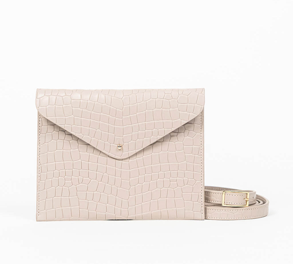 Beige leather clutch bag with a strap on a white background