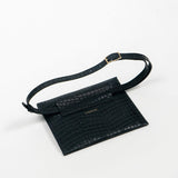 Back of a black leather clutch bag with a strap on a white background, right side