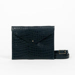 Black leather clutch bag with a strap on a white background