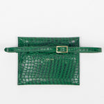 Back of a green leather clutch bag with a strap on a white background