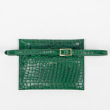 Back of a green leather clutch bag with a strap on a white background
