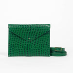 Green leather clutch bag with a strap on a white background