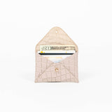 Open beige leather cardholder on a white background