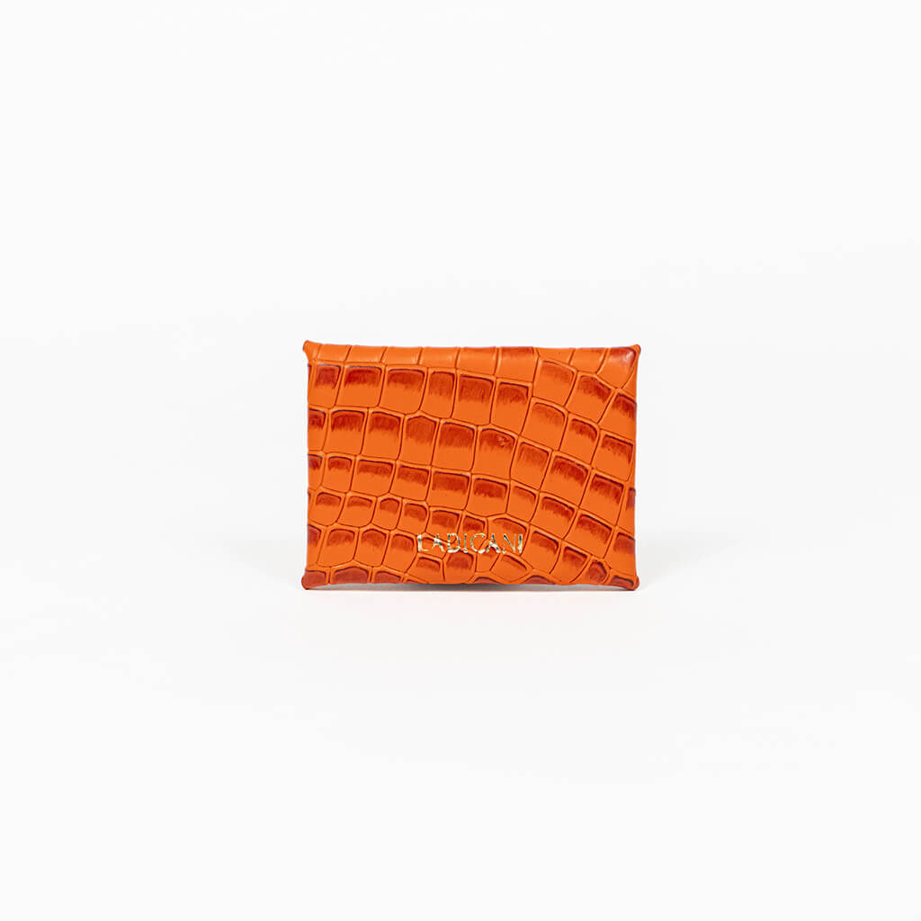 Back of an orange leather cardholder on a white background