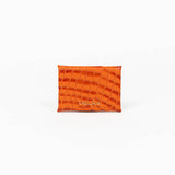 Back of an orange leather cardholder on a white background