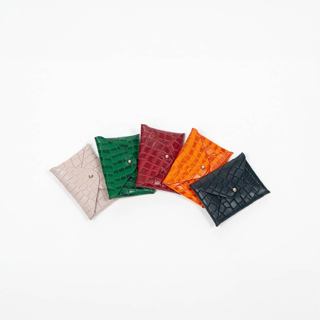 Five leather cardholders in different colors on a white background