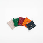 Five leather cardholders in different colors on a white background