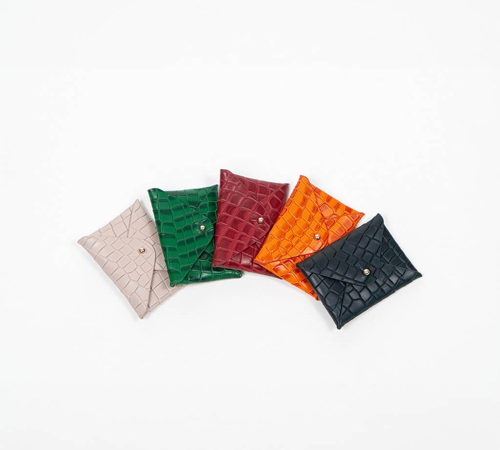 Five leather cardholders in different colors on a white background