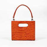 Orange textured cassette bag with a visible brand logo and strap on a white background