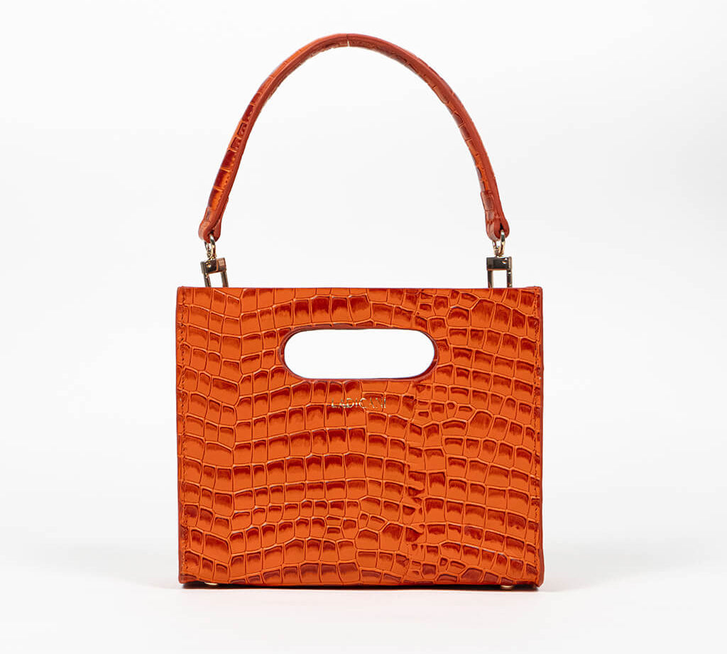 Orange textured cassette bag with a visible brand logo and strap on a white background