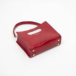 Beige textured cassette bag with a visible brand logo and strap laying down on a white background