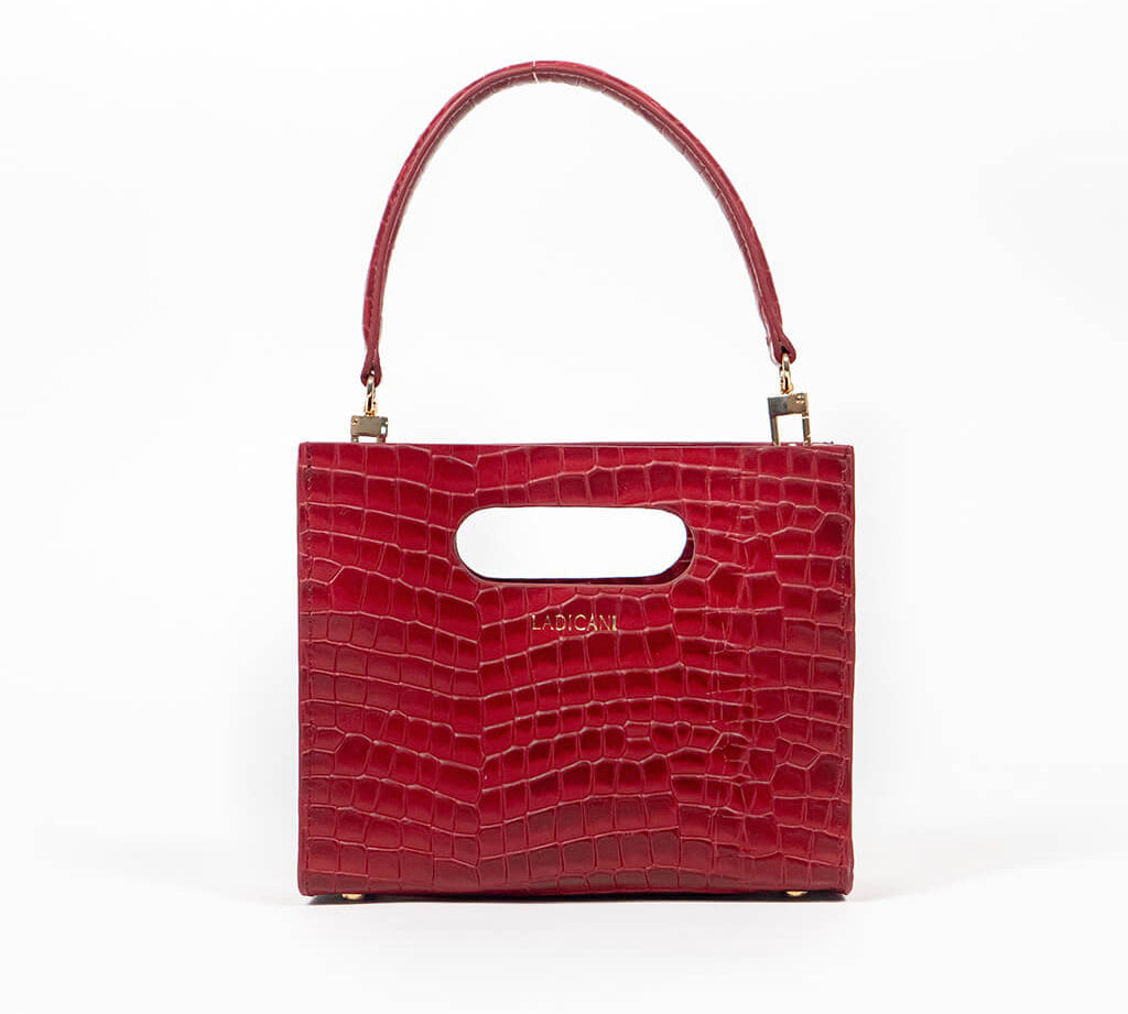 Red textured cassette bag with a visible brand logo and strap on a white background