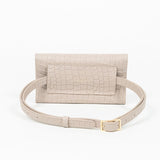 Back of a beige mini clutch bag with matching belt on a white background