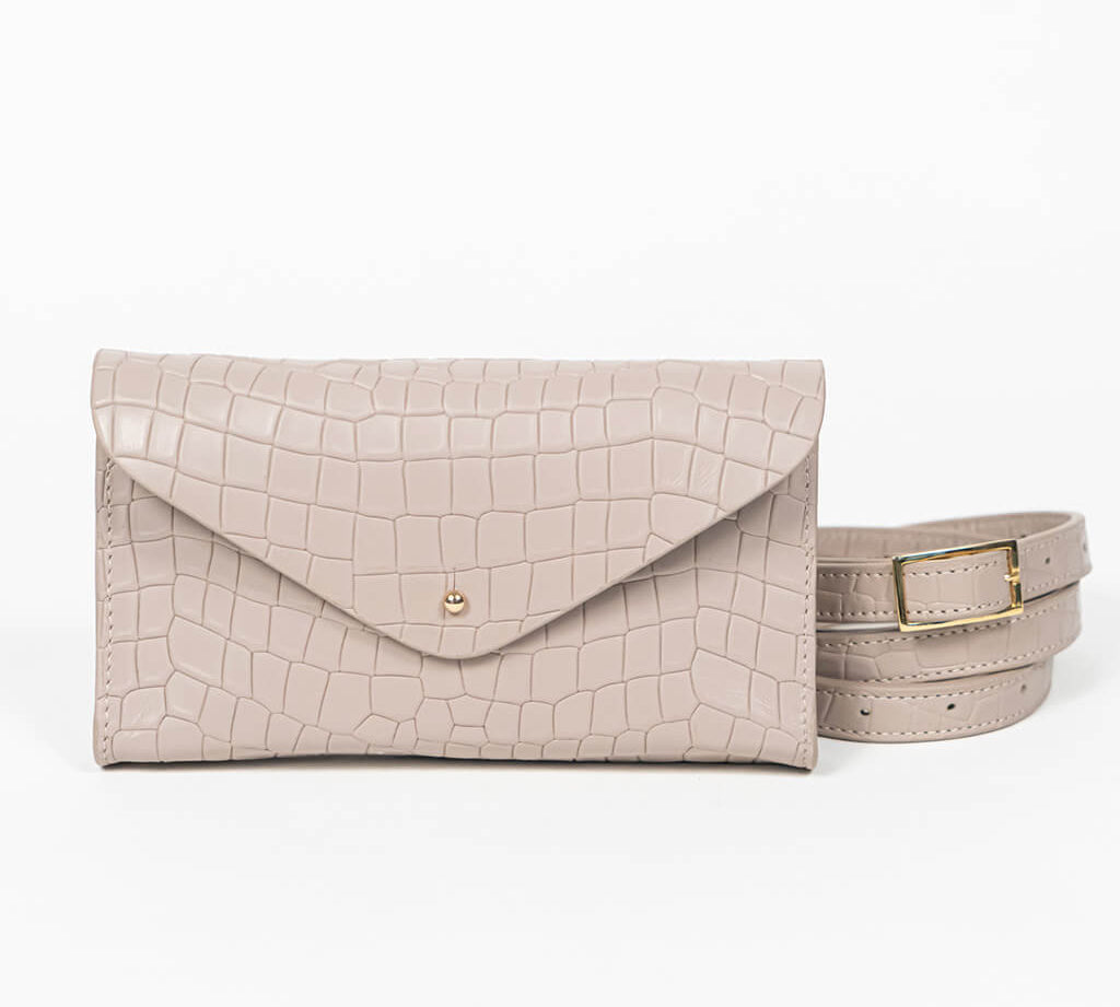 Beige mini clutch bag with matching belt on a white background