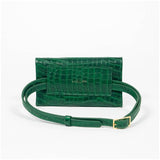 Back of a green mini clutch bag with extended matching belt on a white background