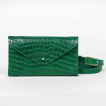 Green mini clutch bag with matching belt on a white background