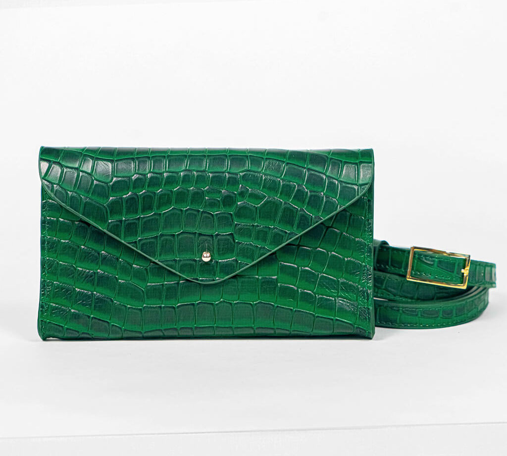 Green mini clutch bag with matching belt on a white background