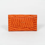 Back of an orange mini clutch bag on a white background