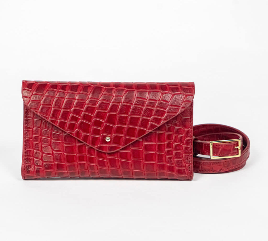 Red mini clutch bag with matching belt on a white background