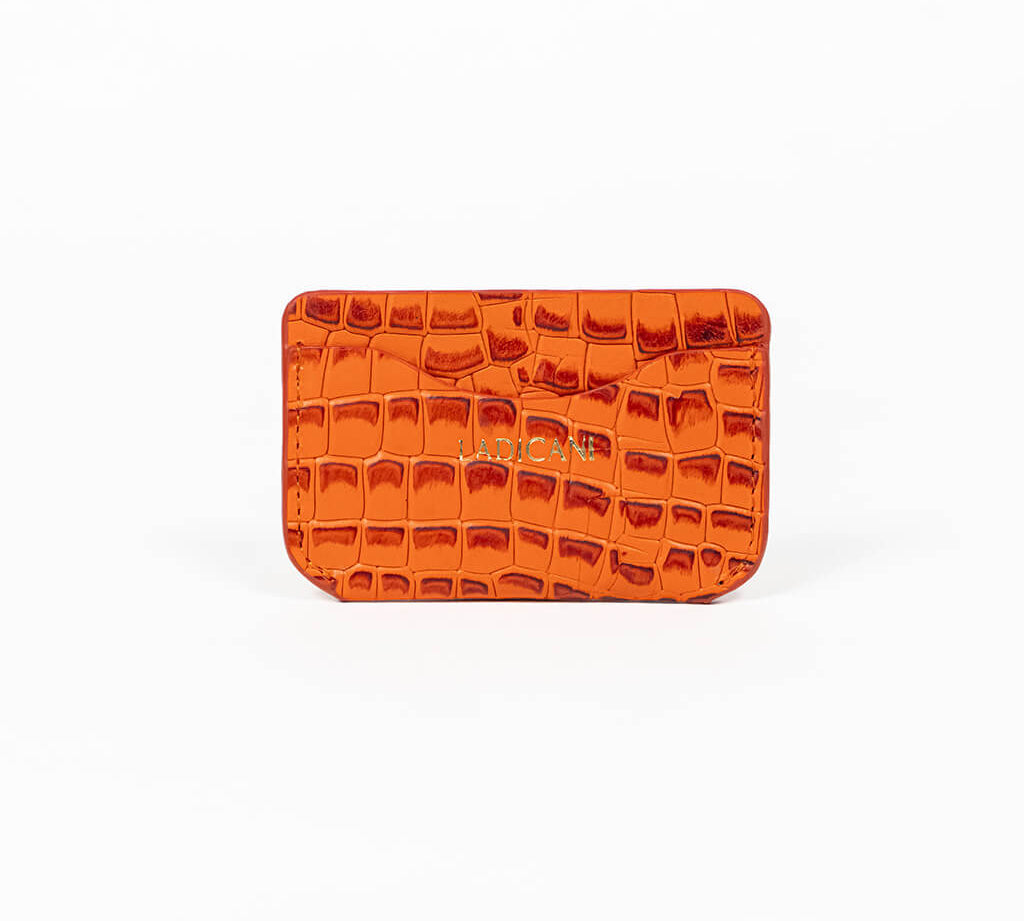 Orange leather slim wallet with branding on a white background